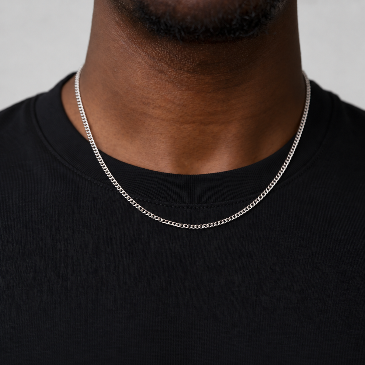 2mm silver Cuban chain, black tee studio model photograph.
