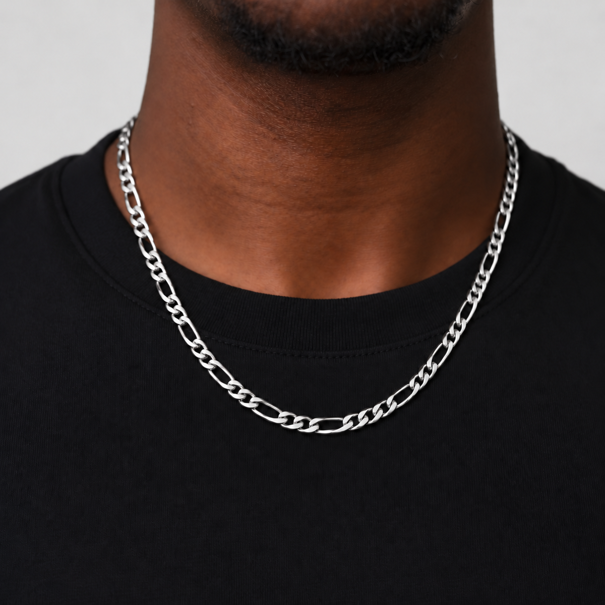 Unveiled 5mm Figaro chain in stainless steel silver, 50cm, worn by the Unveiled model in a black cotton tee