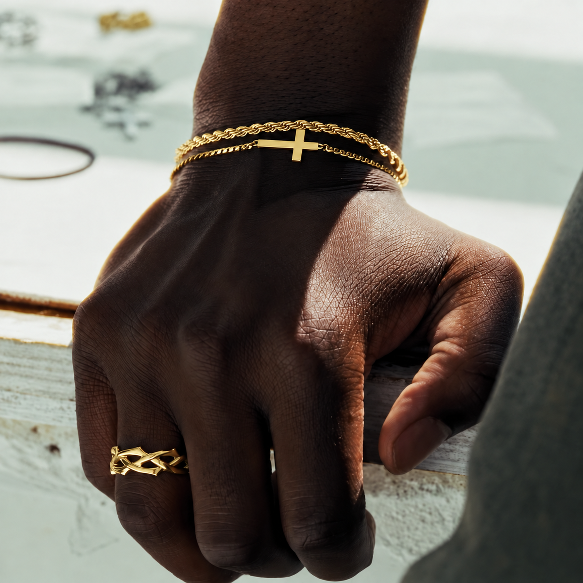 Gold rope bracelet, cross bracelet and Crown of Thorns ring worn together, square lifestyle photo