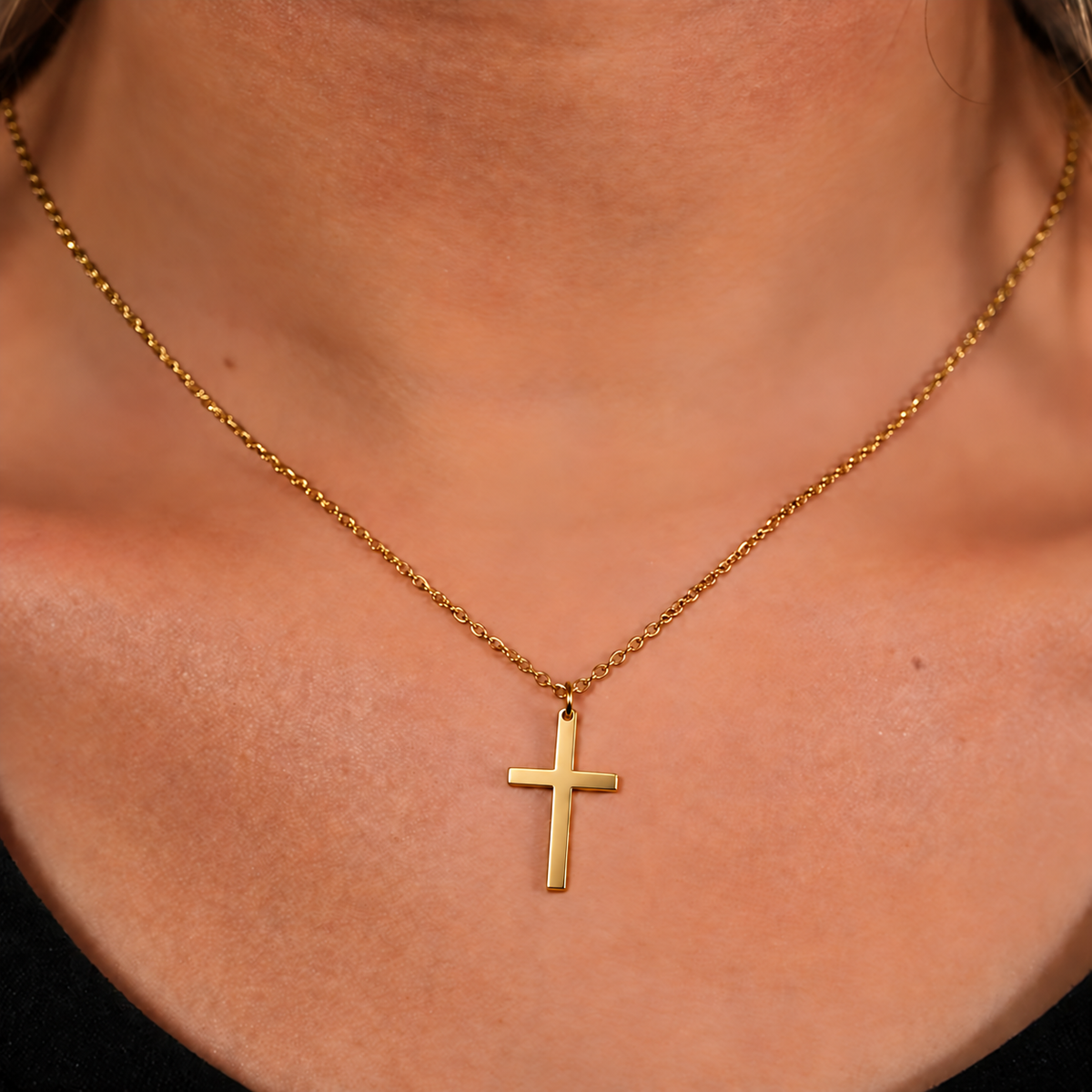 Polished gold cross necklace worn by a woman, square lifestyle photo