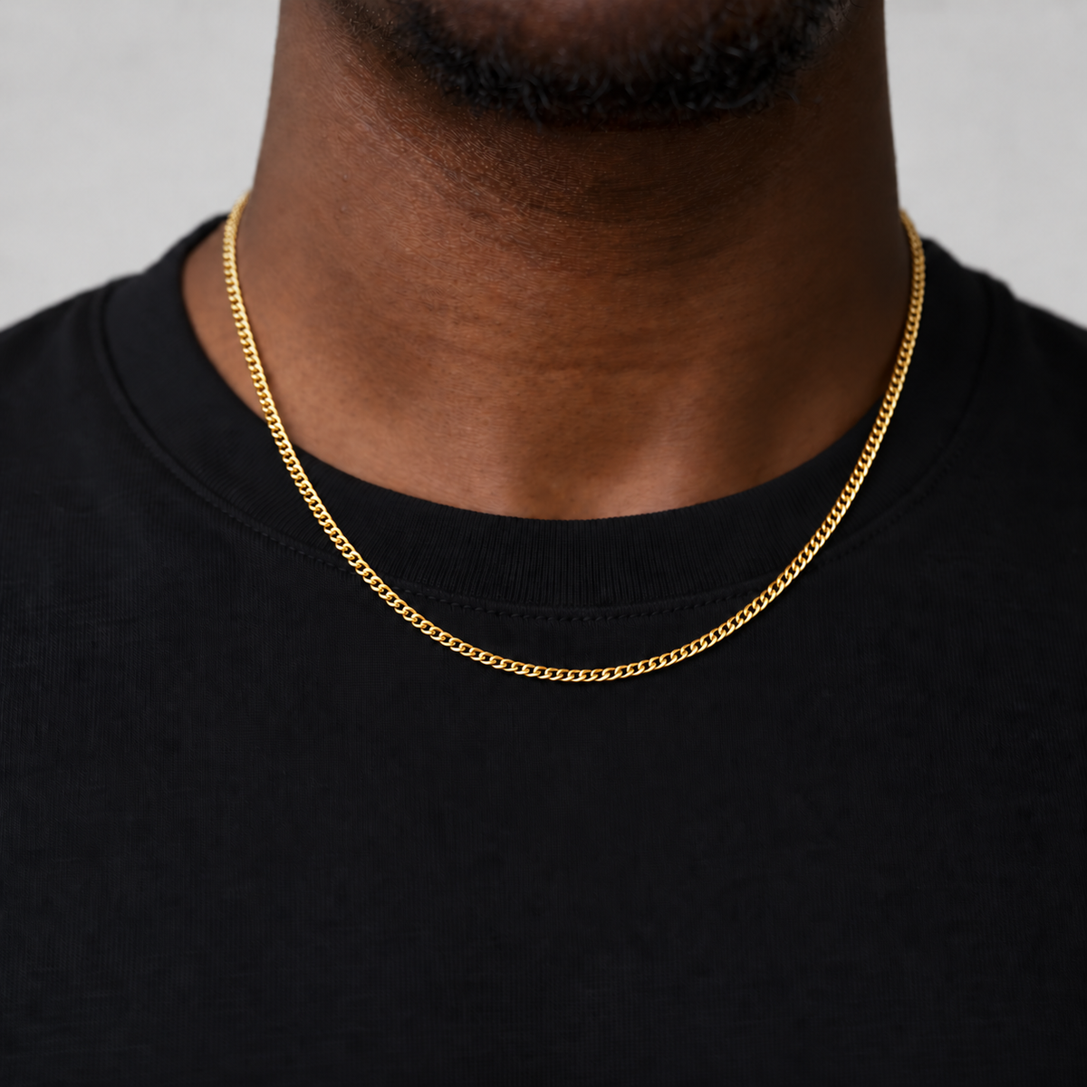 2mm Cuban chain in an 18k PVD gold finish, black tee studio model photograph.