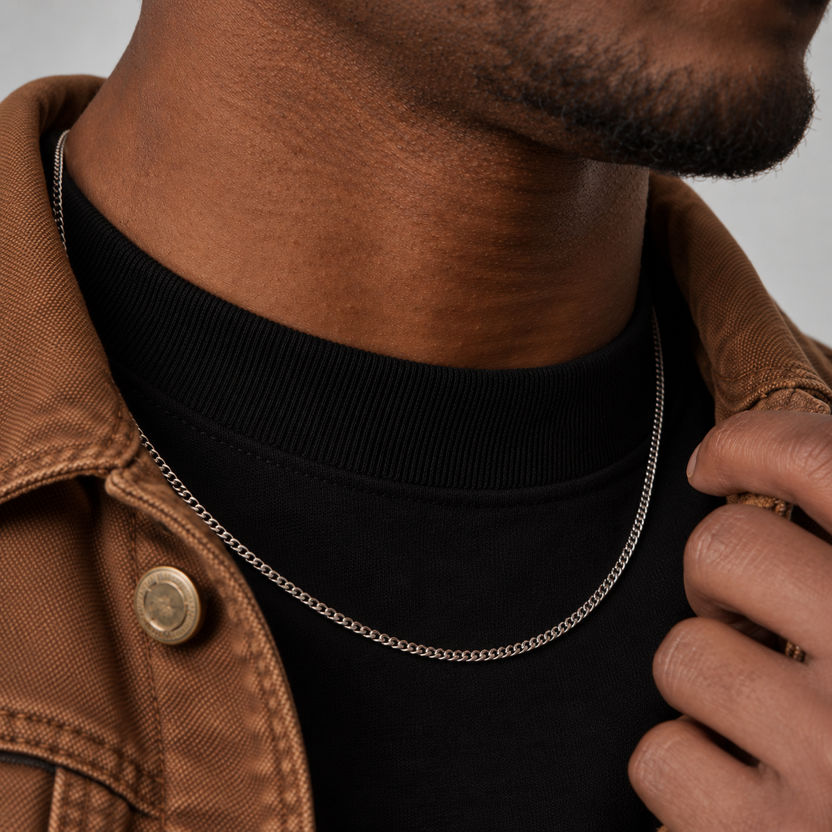 2mm silver Cuban chain, brown workwear jacket side view model photograph.