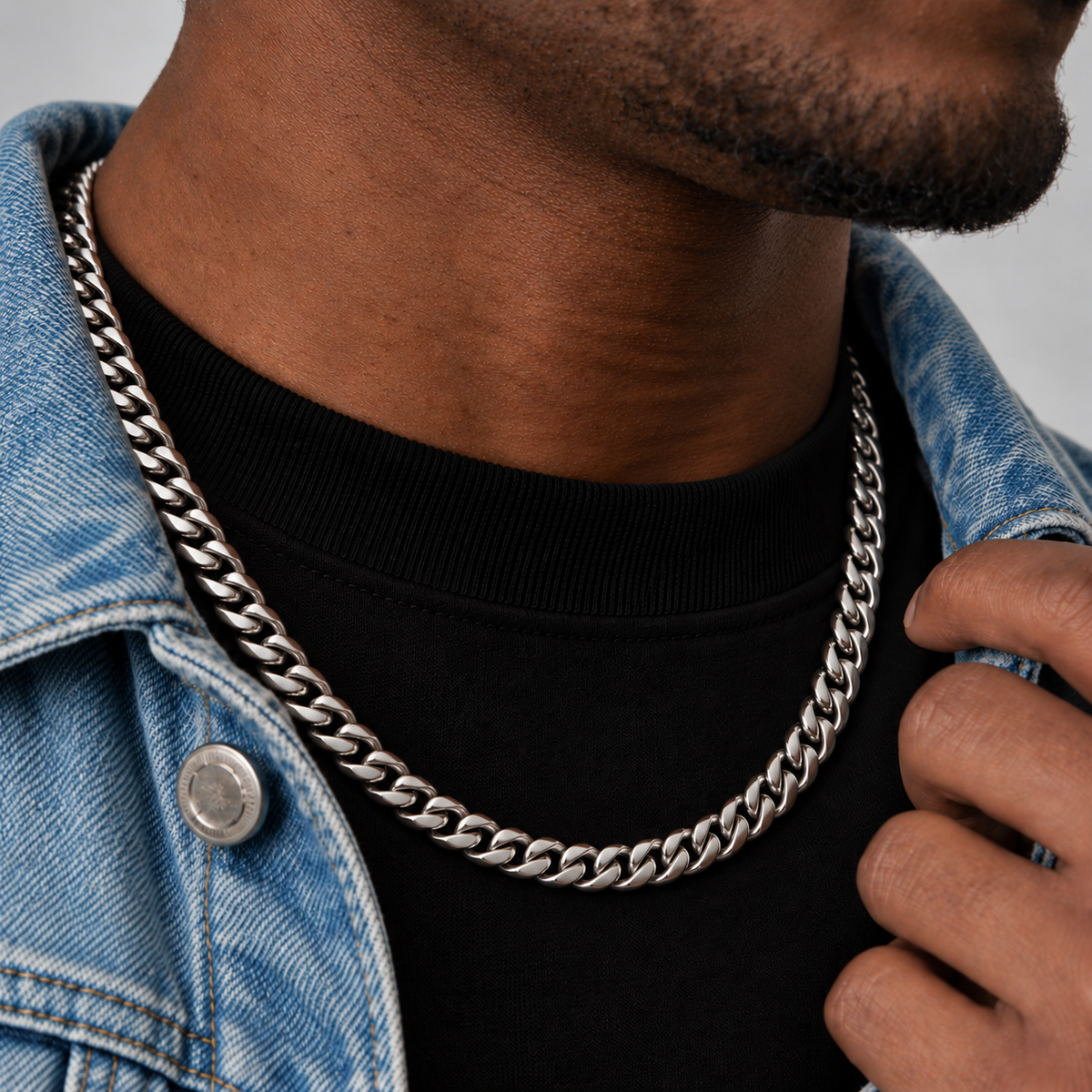 8mm silver Cuban chain, denim looking-away side view, Unveiled website product photograph.