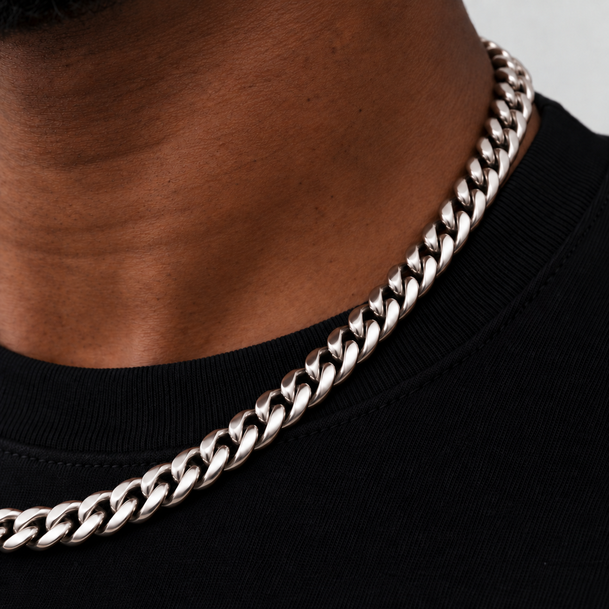 8mm silver Cuban chain, neckline close-up, Unveiled website product photograph.