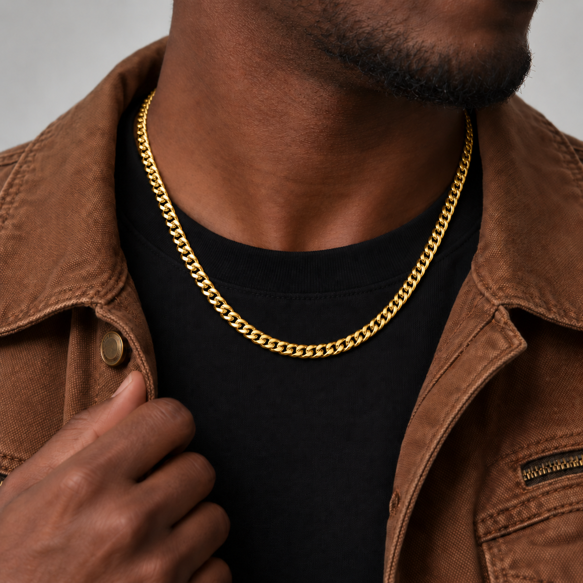 6mm 18k PVD gold Cuban chain, brown workwear jacket, Unveiled website product photograph.