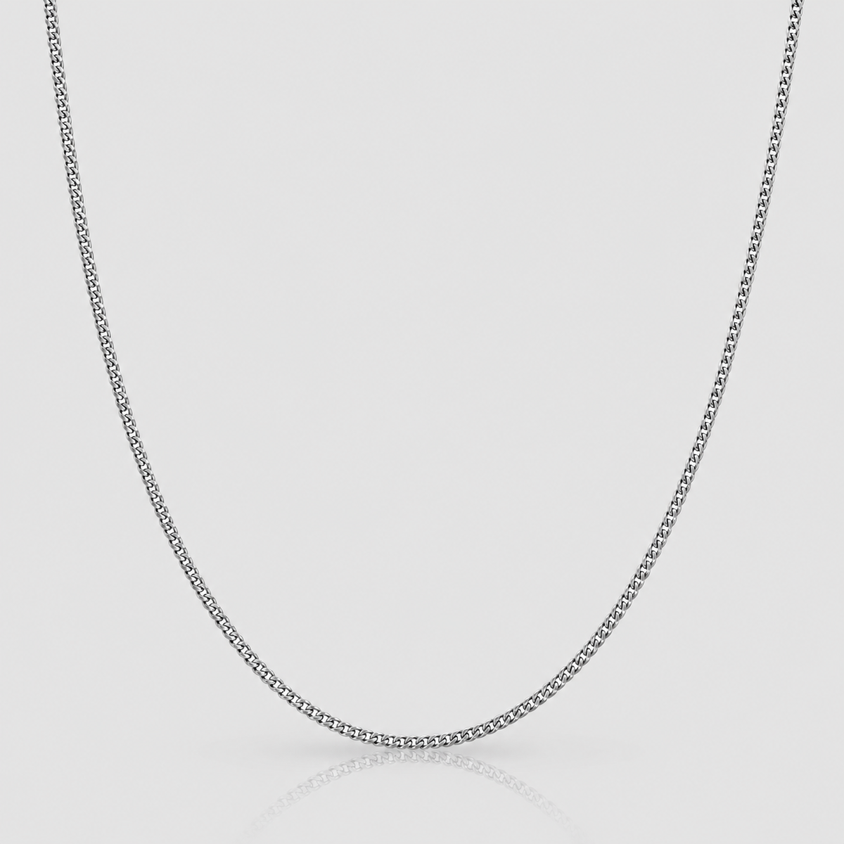 2mm silver Cuban chain on Unveiled light-grey background, standalone product photograph.