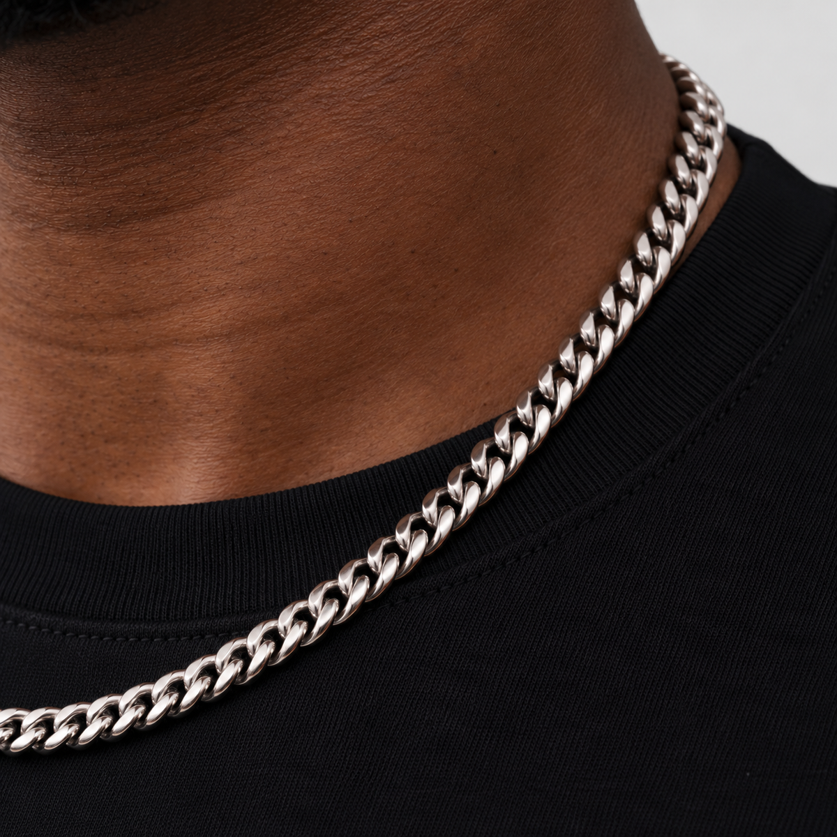 6mm silver Cuban chain, neckline macro, Unveiled website product photograph.