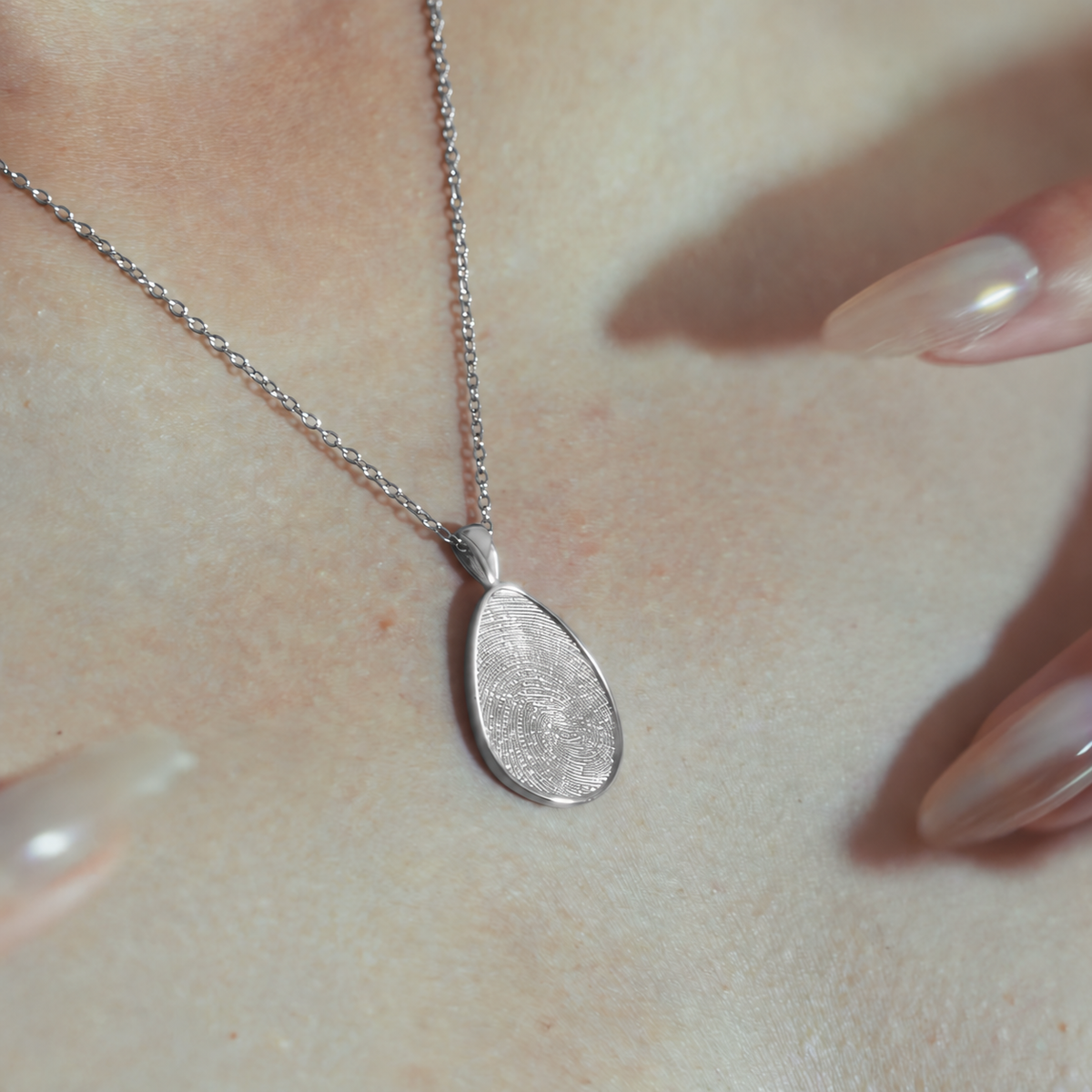 Silver fingerprint pendant worn, close-up