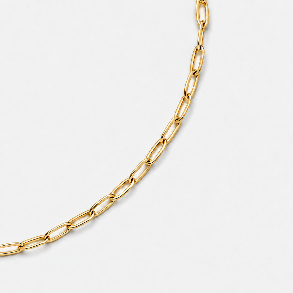 Paperclip Chain gold polished link detail on light grey background