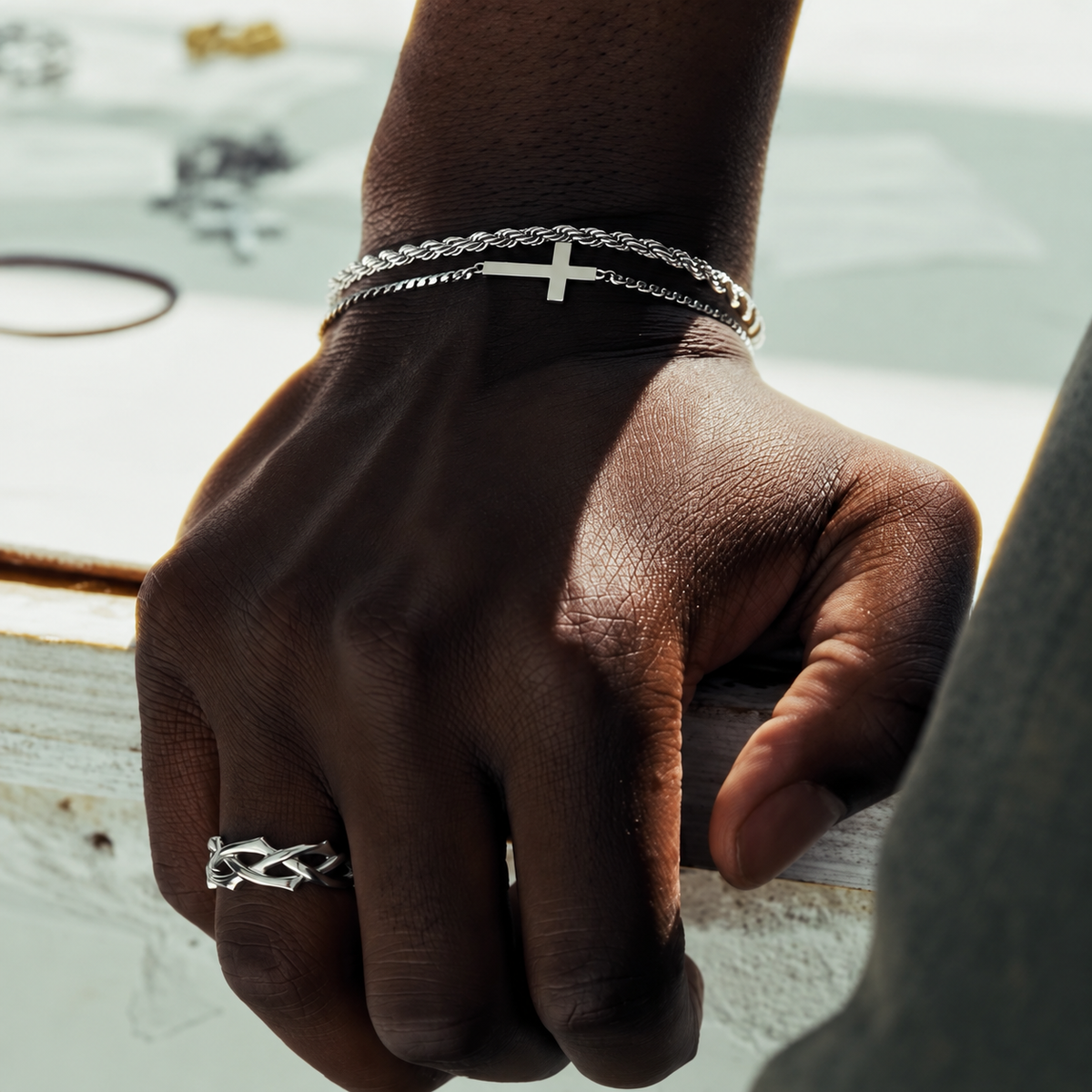 Silver rope bracelet, cross bracelet and Crown of Thorns ring worn together, square lifestyle photo