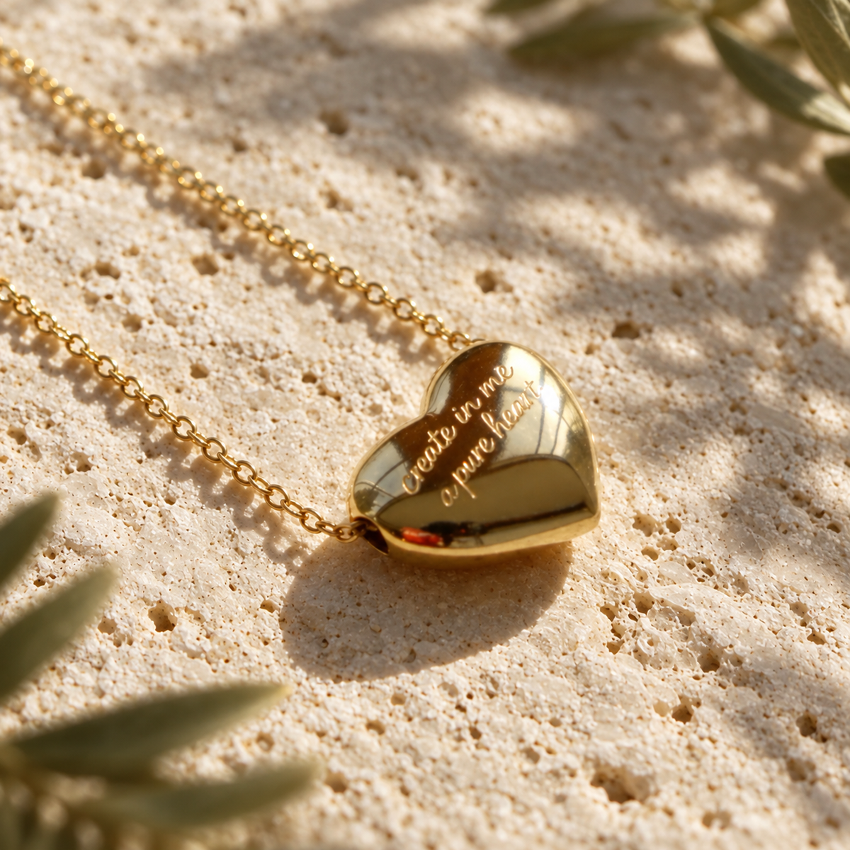 Gold heart necklace engraved create in me a pure heart on sunlit travertine