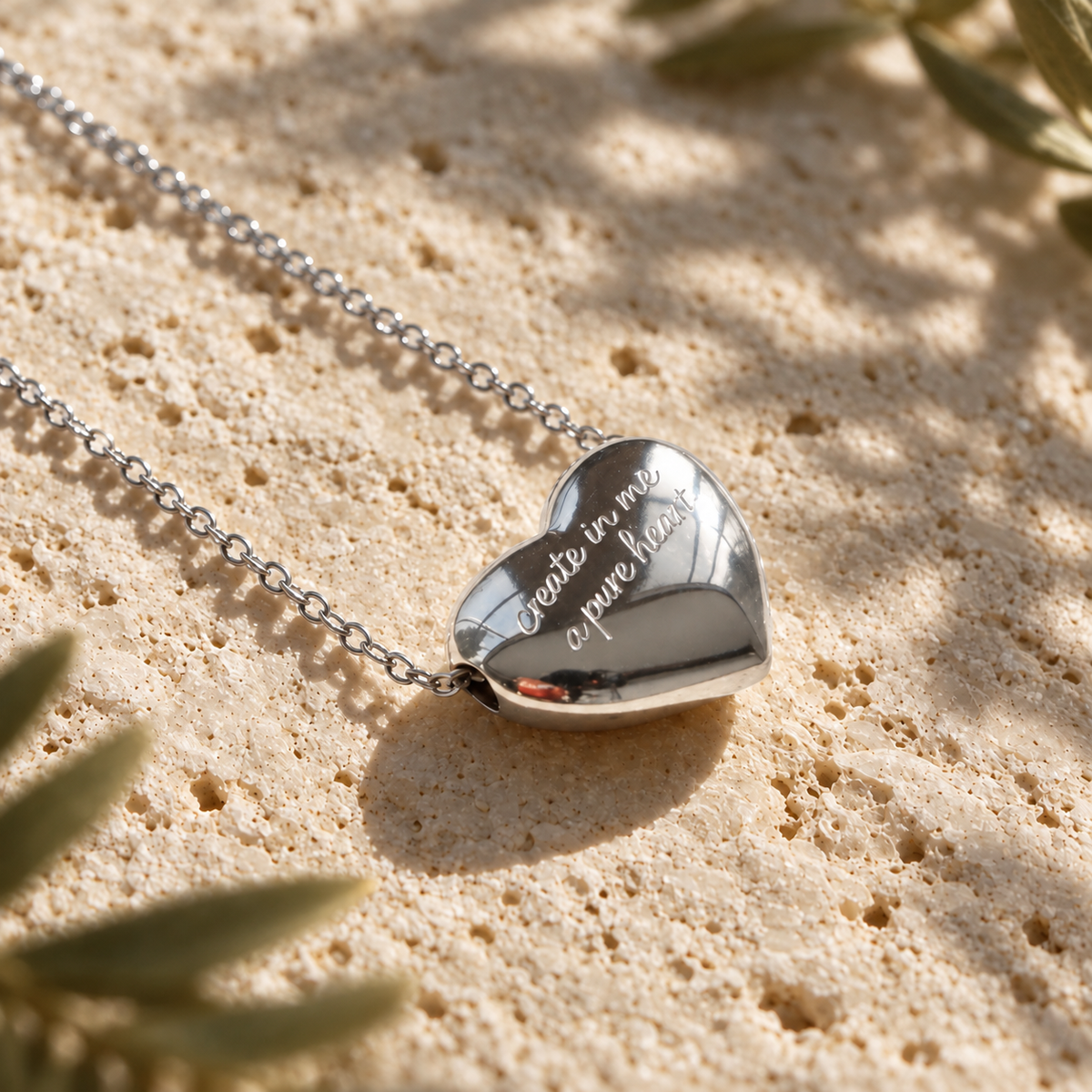 Silver heart necklace engraved create in me a pure heart on sunlit travertine