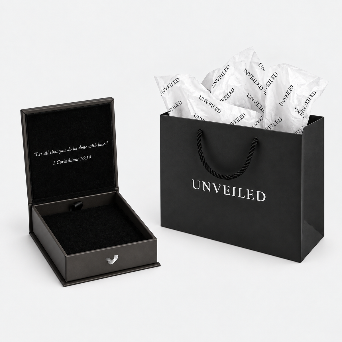 Unveiled gift bag and open luxury gift box arranged separately on a light grey background