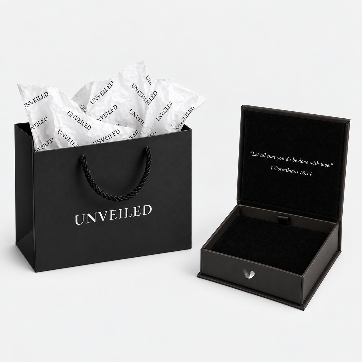 Unveiled gift bag and open luxury gift box arranged separately on a light grey background